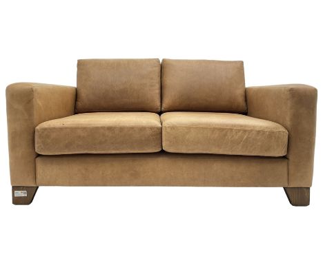 20th century two seat sofa, upholstered in tan leather with loose back and seat cushions, on stained beech tapering feet, wit