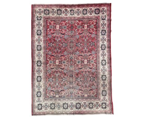 Persian red ground carpet, the field decorated with large floral Herati motifs, ivory ground border decorated with floral pan