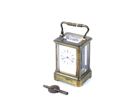 An early 20th century small brass cased carriage clock retailed by Ortner & Houle. The white enamel dial with Roman numerals,