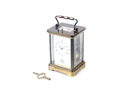 A 20th century Matthew Norman brass cased carriage clock. The white enamel dial with Roman numerals and subsidiary dial, elev