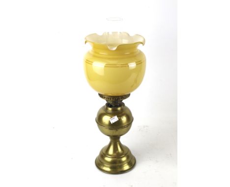 A late 19th century oil lamp. With brass stand and a fluted yellow glass shade, H46cm (excluding funnel)