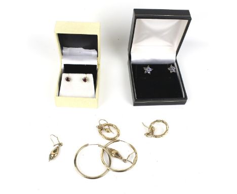 A collection of earrings including two pairs of 9ct gold hoops. These weigh 4.2g; a pair of small oval ruby studs; a pair of 