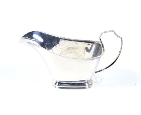 A vintage small silver sauce boat. With a double-scroll handle, an everted rim and bracket hoof feet, hallmarks for Birmingha