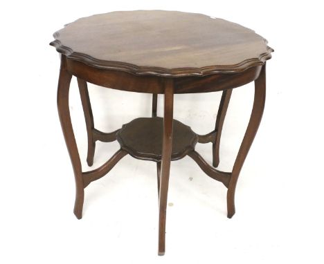 An Edwardian mahogany occasional table. With pie crust edge, raised on six shaped legs, united by a stretcher with circular l