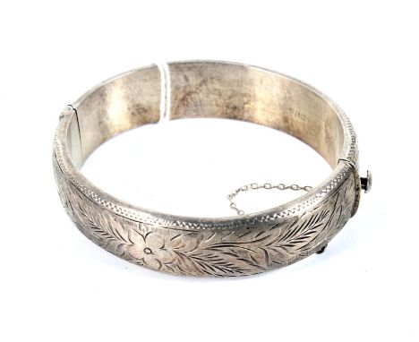 A vintage silver foliate engraved hollow hinged bangle. Hallmarks for Birmingham 1965, approx. 18.5mm wide, 33g