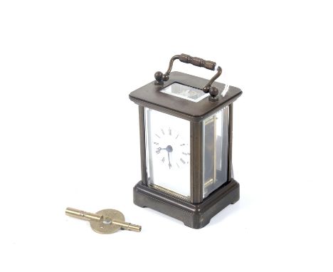 A 20th century small brass cased carriage clock. The white enamel dial with Roman numerals, H9cm (excluding handle)