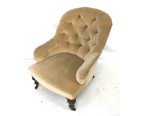 An Edwardian button back armchair on casters. H89cm