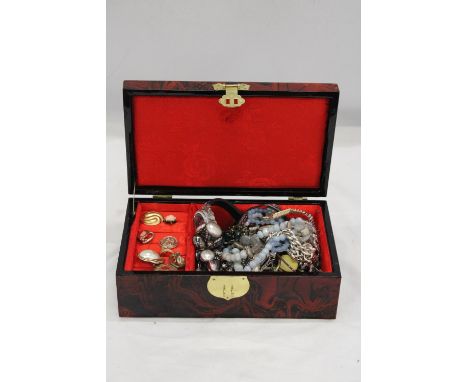A VINTAGE ORIENTAL, RED LACQUER JEWELLERY BOX CONTAINING A QUANTITY OF COSTUME JEWELLERY 