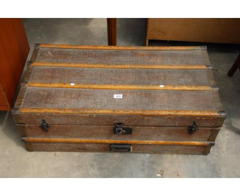 AN EDWARDIAN TRAVELLING TRUNK WITH WOODEN BATONS AND METAL FITTINGS, 36" X 18" 