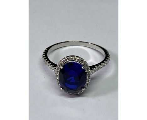 A MARKED 925 RING WITH CENTRE BLUE STONE SURROUNDED CLEAR STONES SIZE P 