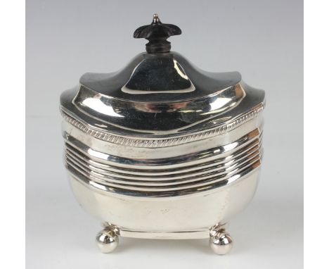 An Edwardian silver tea caddy of cushion form with horizontal banding, the hinged lid with ebony finial, on ball feet, London