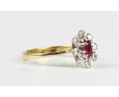 A gold, ruby and diamond oval cluster ring, claw set with the oval cut ruby within a surround of eight circular cut diamonds,