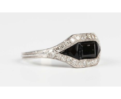 A white gold, onyx and diamond ring in a hexagonal panel design with a border of circular cut diamonds, detailed '750', weigh