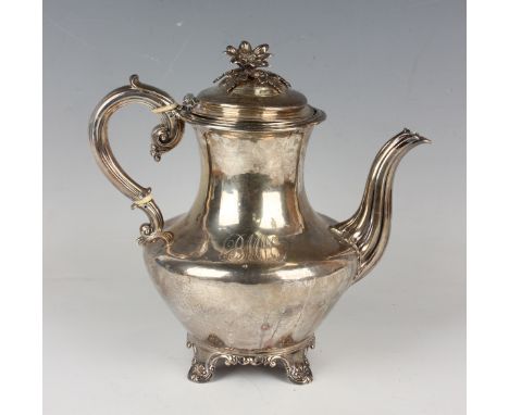 A William IV silver hot water pot of baluster form with hinged lid and flower finial above a scroll handle, on anthemion moul