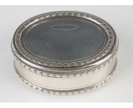 A late 19th century French silver oval snuff box, the hinged lid and sides with engine turned decoration within bellflower bo