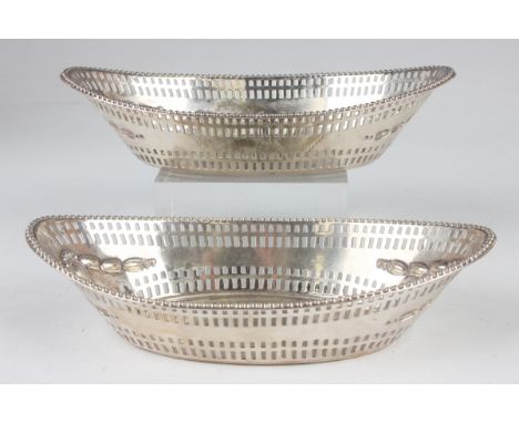 A pair of late Victorian Scottish silver oval bonbon baskets, each with beaded rim above pierced and embossed decoration, Edi