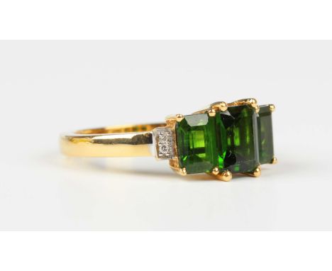 An 18ct gold, chrome diopside and diamond ring, claw set with three graduated rectangular step cut chrome diopside between di