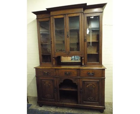 
An Art Nouveau Oak Library Bookcase. The Base with Three Drawers Over Central Open Display Area and Flanked by Two Cupboards