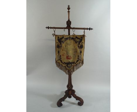 A Mid 19th Century Rosewood Pole Screen, The Reeded Support on Tripod Base with Scrolled Feet. Carved Armorial Shield with Li