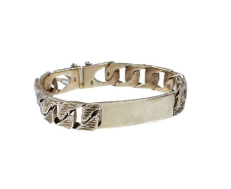 A 9ct gold bangle in the form of a belt with engraved and relief decoration, 10.9 grams