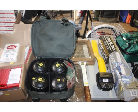 A set of four Green Master bowling woods in bag and a tennis racket