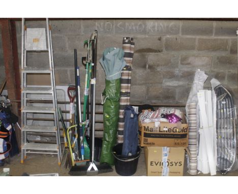 A large garden umbrella with cover, wind break, plastic bucket etc