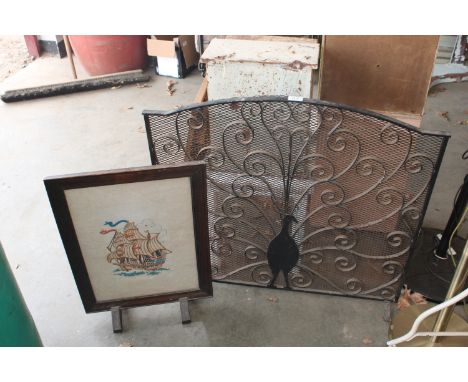 A wrought iron fire guard and an oak framed fire screen having ship decoration