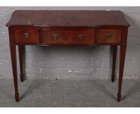 A mahogany three drawer side table raised on reeded tapering supports. (105cm x 80cm)  