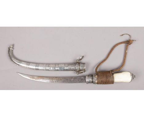 An Eastern bone handle dagger, with white metal mounts and scabbard.  