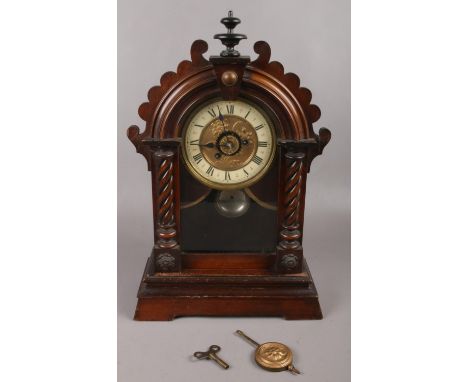 A carved mahogany 8 day mantel clock with gilt &amp; enamel dial.  