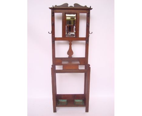 An Edwardian walnut hall stand, the upper section with central bevelled mirror and art nouveau brass hooks, the base with cen