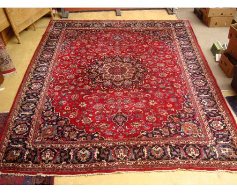 A large Persian meshed carpet, red ground field with central medallion within foliate borders.
372 x 301cm. 