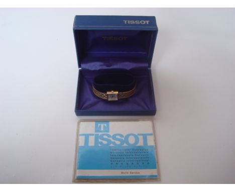 A ladies 9 carat gold Tissot strlist wristwatch, the rectangular silvered dial with baton markers, manual wind movement, on T