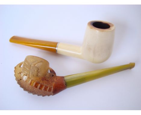 A Meerschaum pipe, the bowl  as a claw holding an egg together with another plain example (2). 