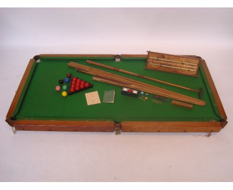 An Edwardian quarter size oak table top snooker / billiards table with slate bed, with a set of composite snooker and billiar