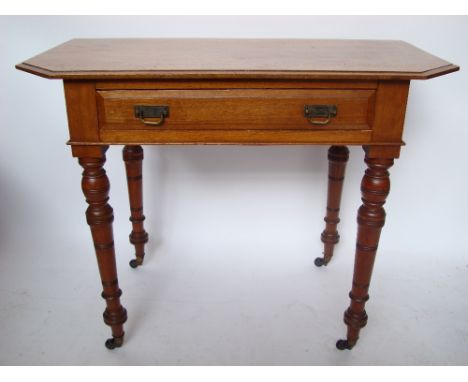 A late Victorian James Shoolbred & Co walnut writing table, the rectangular top with moulded edge and cut off corners above a