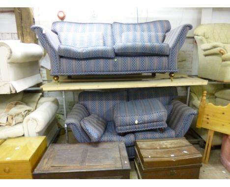 AN UPHOLSTERED THREE PIECE SUITE, comprising of a three seater settee, a two seater settee and a pouffe