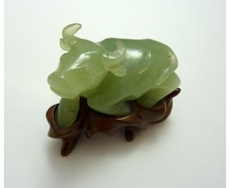 A CARVED JADE BISSON ON A STAND