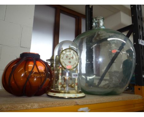A DOMED KUNDO CLOCK, brass oil lamp, a glass shade and a glass carbuoy