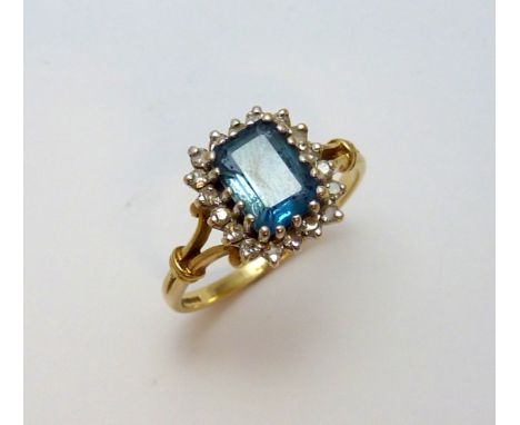 A 9CT GOLD ZIRCON AND DIAMOND RING, the rectangular shape blue zircon within a surround of single cut diamonds, hallmarks for