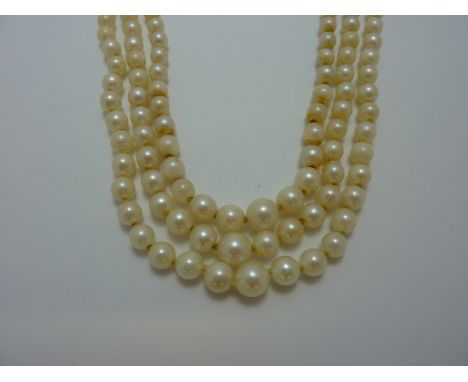 A TRIPLE STRAND OF GRADUATED PEARLS, with bow shape paste clasp (s.d.)