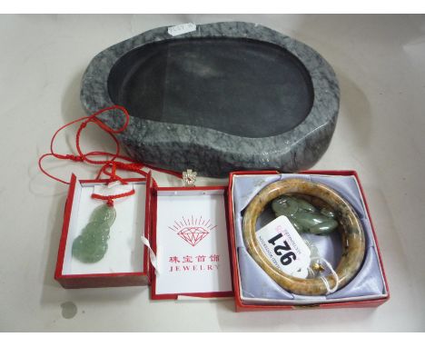 A PAIR OF RUSSET JADE BANGLES, together with a dark green Jade figure of a dragon, a russet streaked white Jade pendant, a pa