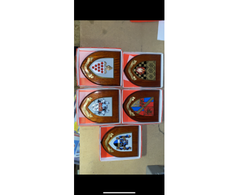 A collection of boxed wooden heraldic shields each with hand painted raised shield, including Surrey, Manchester Met Uni, Can