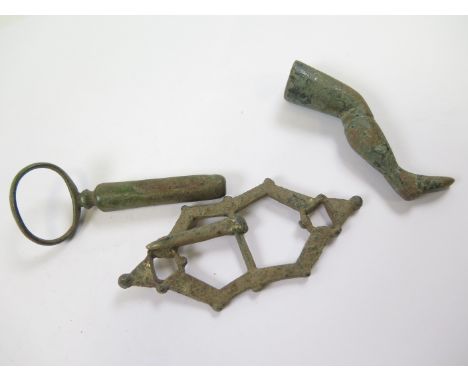 Two pipe tamplers, one in the form of a human leg, the other with a ring attachment, together with a large buckle, originally
