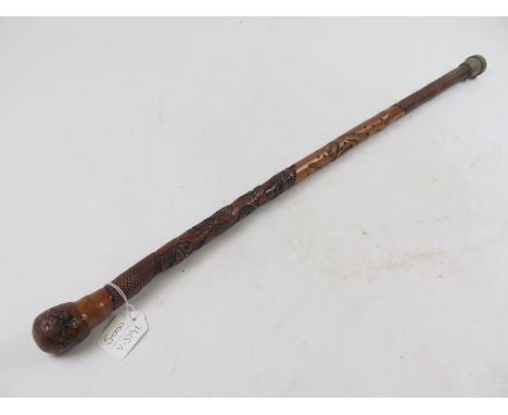 Fine walking stick from Africa. Beautifully carved from bamboo (?). The shaft shows a monkey in a coco nut tree with a large 