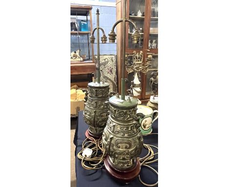 A pair of Chinese metal lamps decorated in archaistic fashion on wooden bases, lamp body is 32cm high