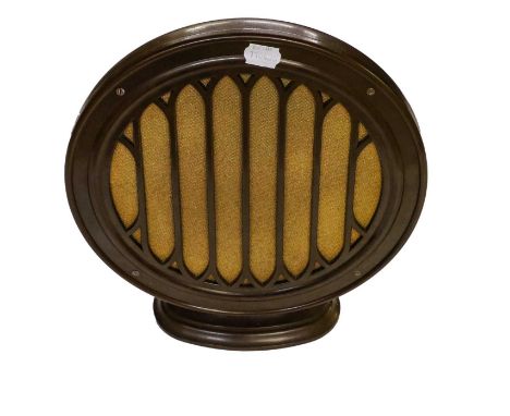 full brown bakelite body with circular fret aperture backed with period cloth, central driver to centre, on oval base.Conditi