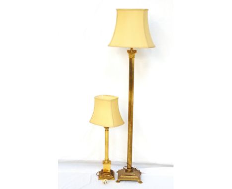 BRASS STANDARD LAMPwith a pale green shaped shade above a Corinthian style column with acanthus leaf decoration, on a square 