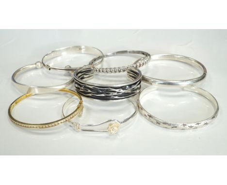 SELECTION OF EIGHT SILVER BANGLESof various designs, including a CZ set silver gilt example, a star engraved bangle and anoth