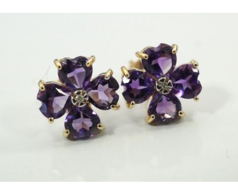 PAIR OF AMETHYST AND DIAMOND STUD EARRINGSin the form of four leaf clovers, the central diamond on each surrounded by four he